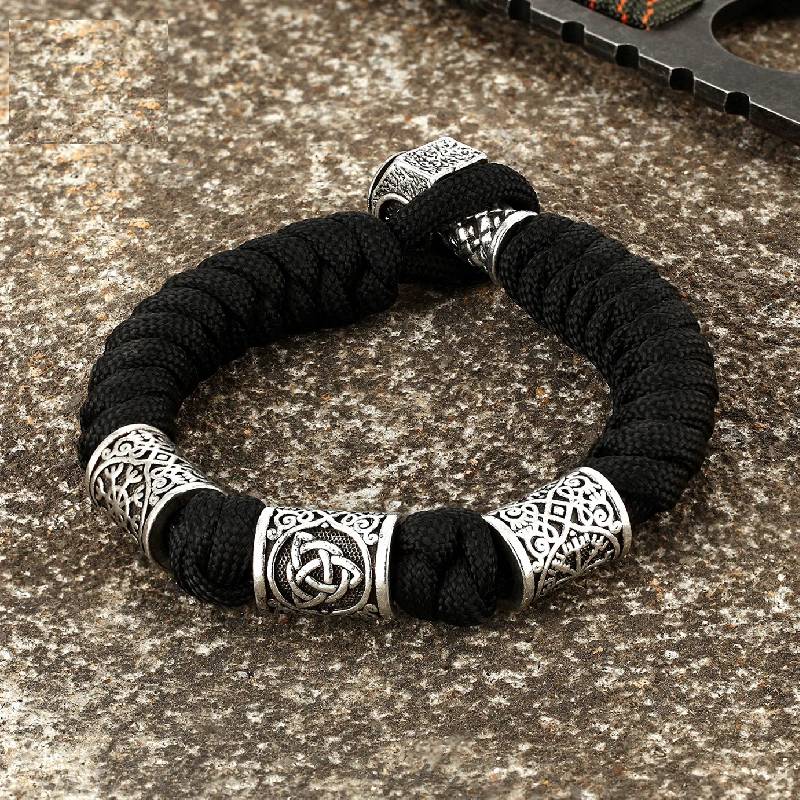 Black paracord survival bracelet with Celtic knot and trinity rune beads.