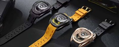 Three Tsar Bomba watches displayed side by side, featuring bold, futuristic designs with geometric dials. The watches have black, yellow, and rose gold accents with matching rubber straps, set against a dark, textured background, showcasing their sporty and modern aesthetic.