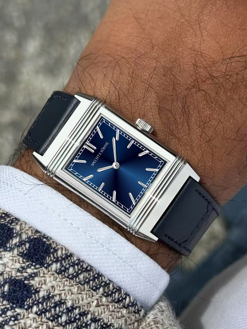 Specht & Söhne Overturn reversible watch worn on wrist, featuring a blue sunburst dial, rectangular stainless steel case, and black leather strap.
