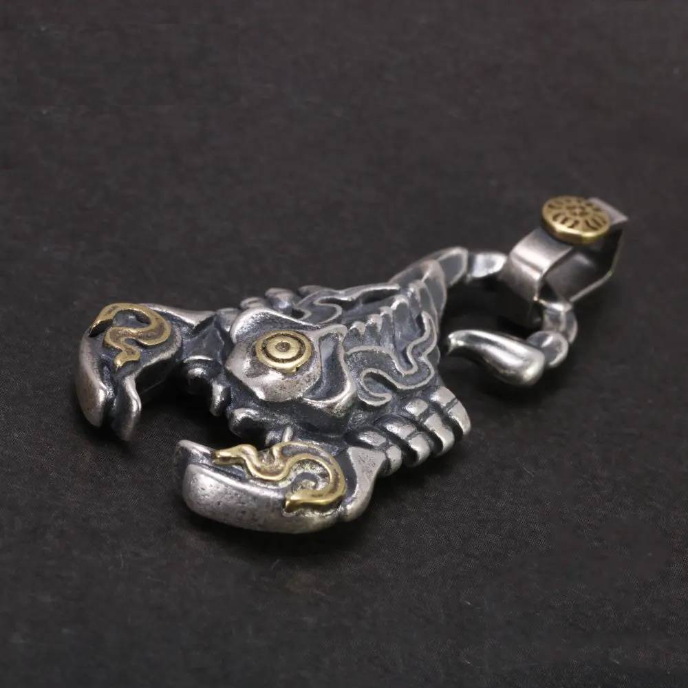 Close-up of handcrafted scorpion skeleton pendant in oxidized 925 sterling silver with tribal detailing and gold accents – punk gothic jewelry style