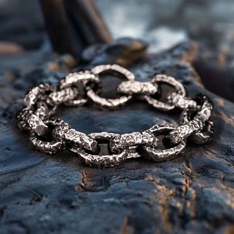 Close-up of hammered stainless steel Nordic rune bracelet for men on stone surface