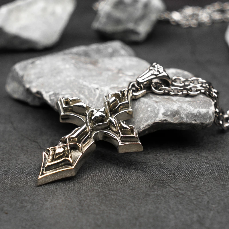 Gothic stainless steel cross pendant necklace for men placed on stone background