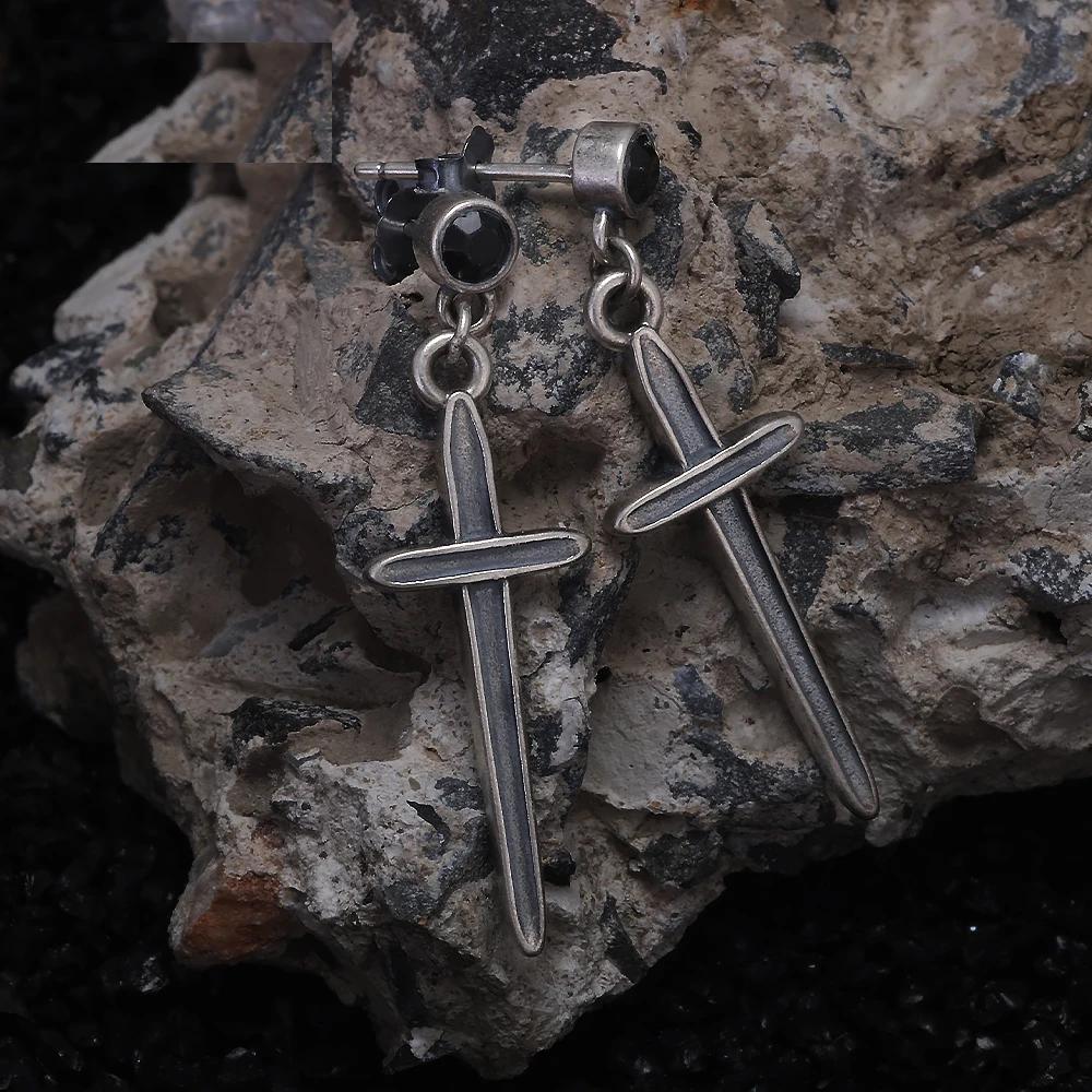 Silver sword cross earrings on stone background – black zircon studs