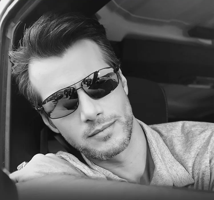Man wearing Cook Shark polarized sunglasses, leaning out of a car window with a confident expression. The sunglasses feature a sleek wraparound design, ideal for driving and outdoor use.