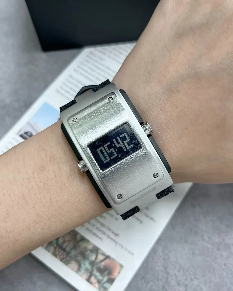 BENLYDESIGN M400 brushed rectangle digital watch with pixel LCD screen, exposed screws, and suede strap.