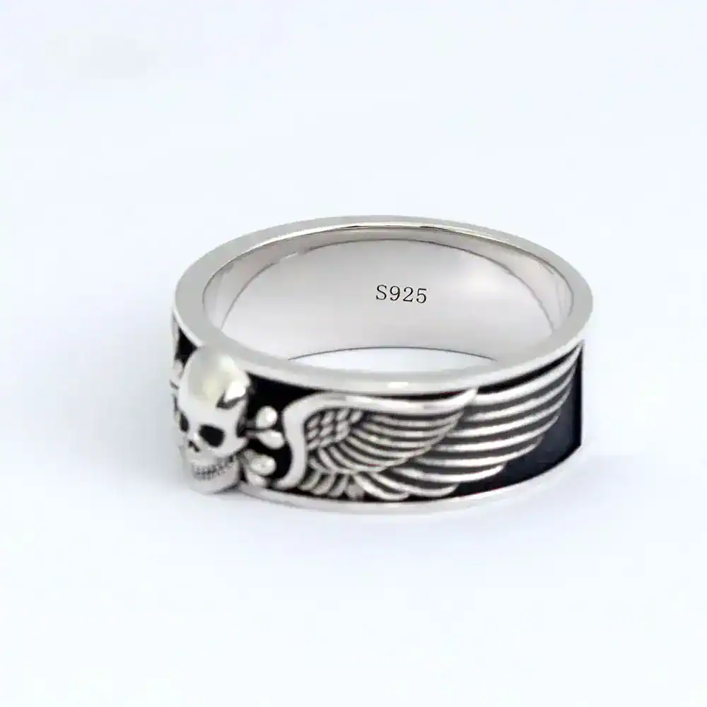 Sterling silver skull wing ring with black enamel details for a edgy jewelry statement.