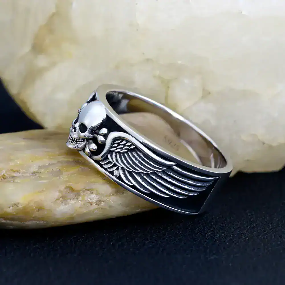 Men's silver skull ring with detailed wing design, edgy gothic jewelry accessory.