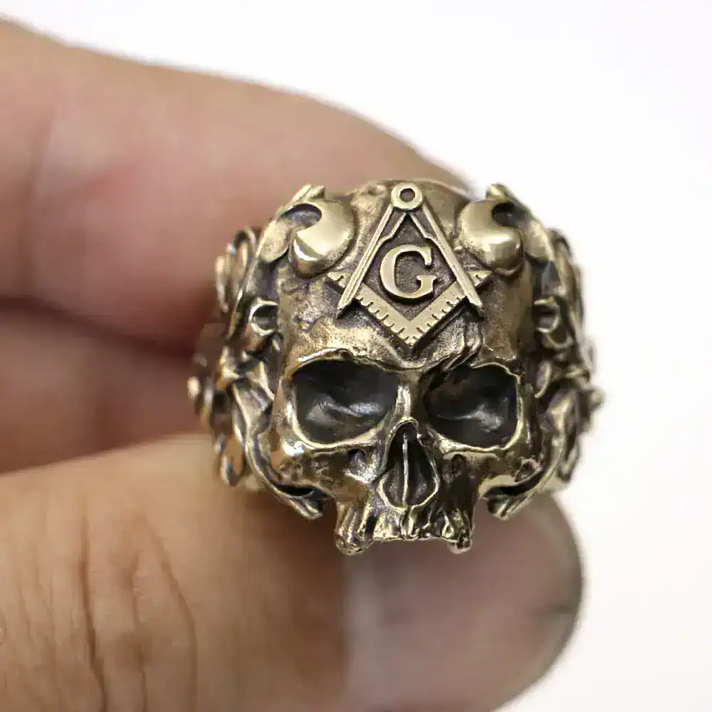 Detailed metallic skull ring featuring Masonic square and compass with G emblem.