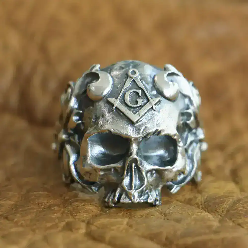 Detailed silver skull ring with Masonic symbols and engravings, bold jewelry for men and women.