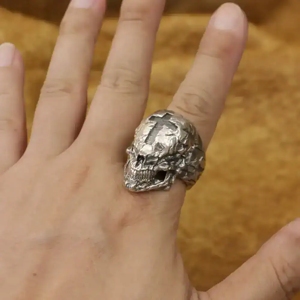 Intricate silver skull ring with cross detail, edgy jewelry for men and women.