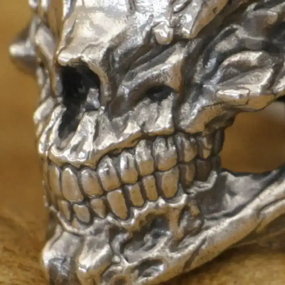 Highly detailed metallic skull pin, gothic-inspired accessory for jewelry enthusiasts.