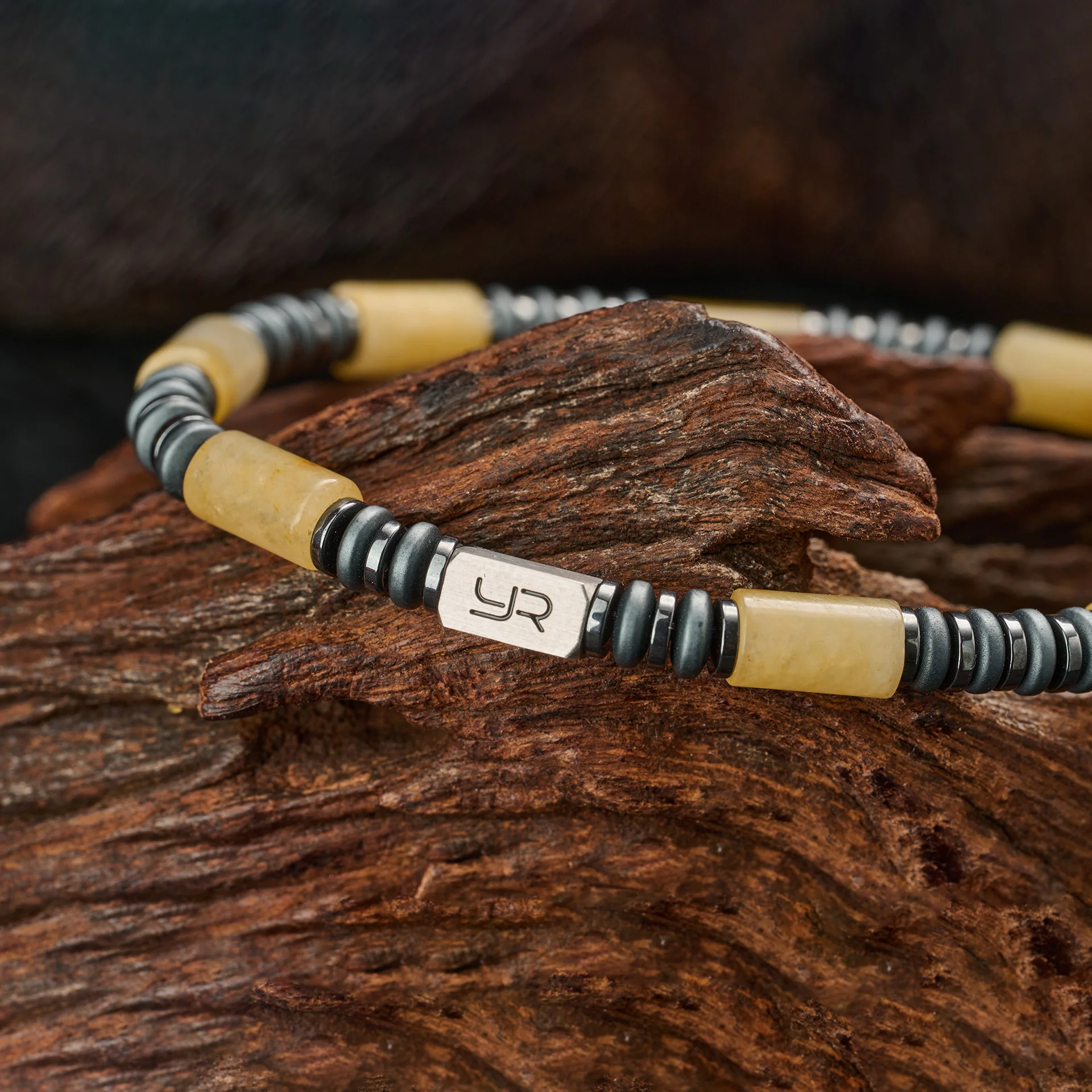 Bracelet featuring black and yellow beads with engraved metal plaque, stylish jewelry accessory.