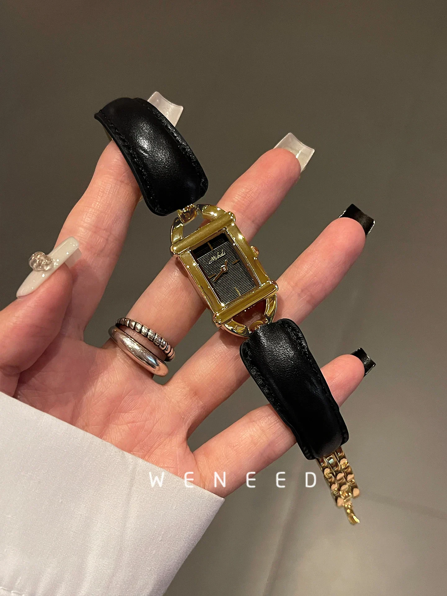 Elegant women's wristwatch with black leather strap, gold accents, and classic design.