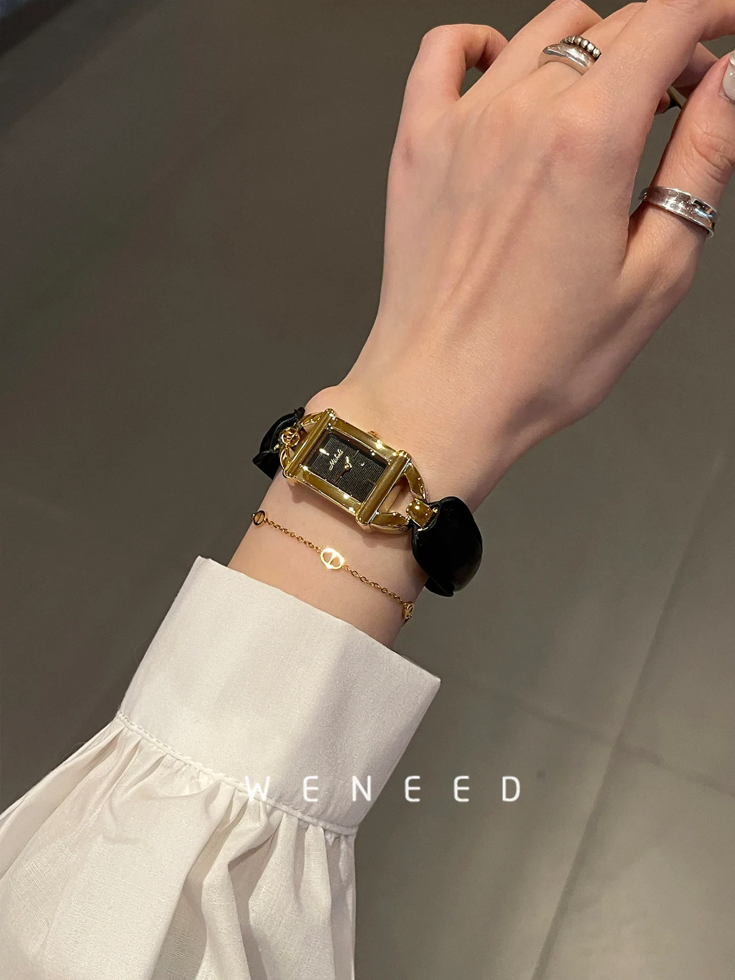Luxury women's wristwatch with gold-tone case and black strap, perfect for fashion-forward looks.