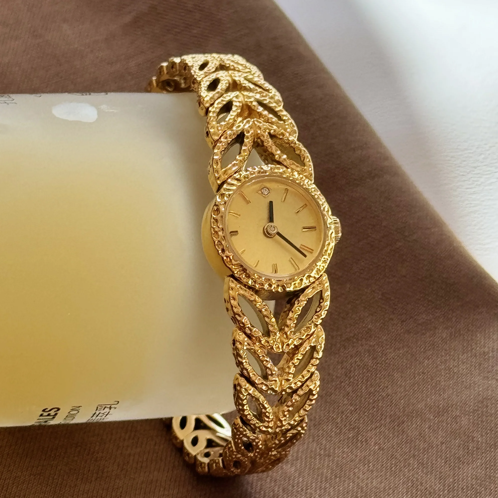 Gold leaf wristwatch with intricate design and luxury appeal. Perfect for stylish women’s accessories.