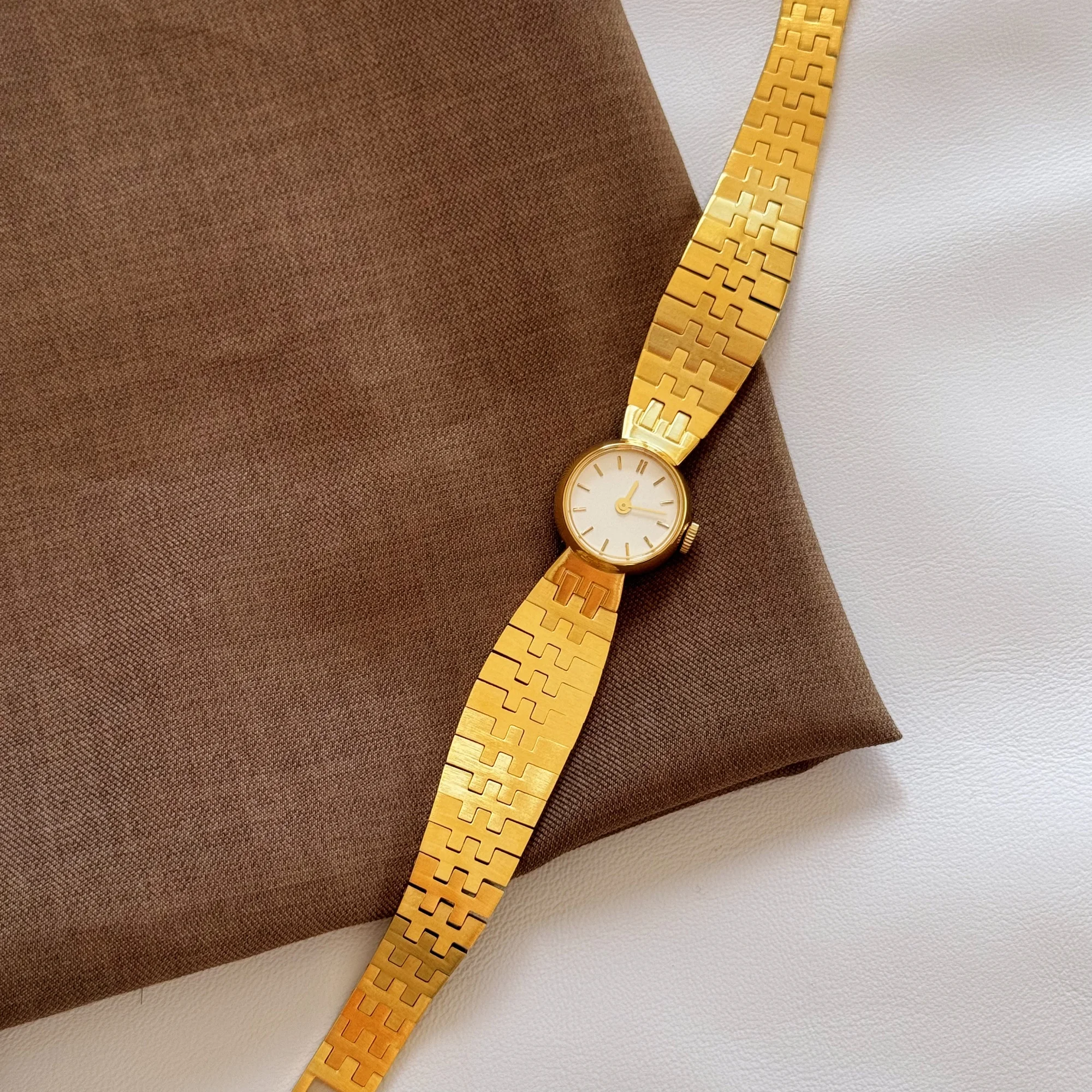 Luxurious gold-tone women's wristwatch with modern geometric bracelet, perfect for stylish accessories.