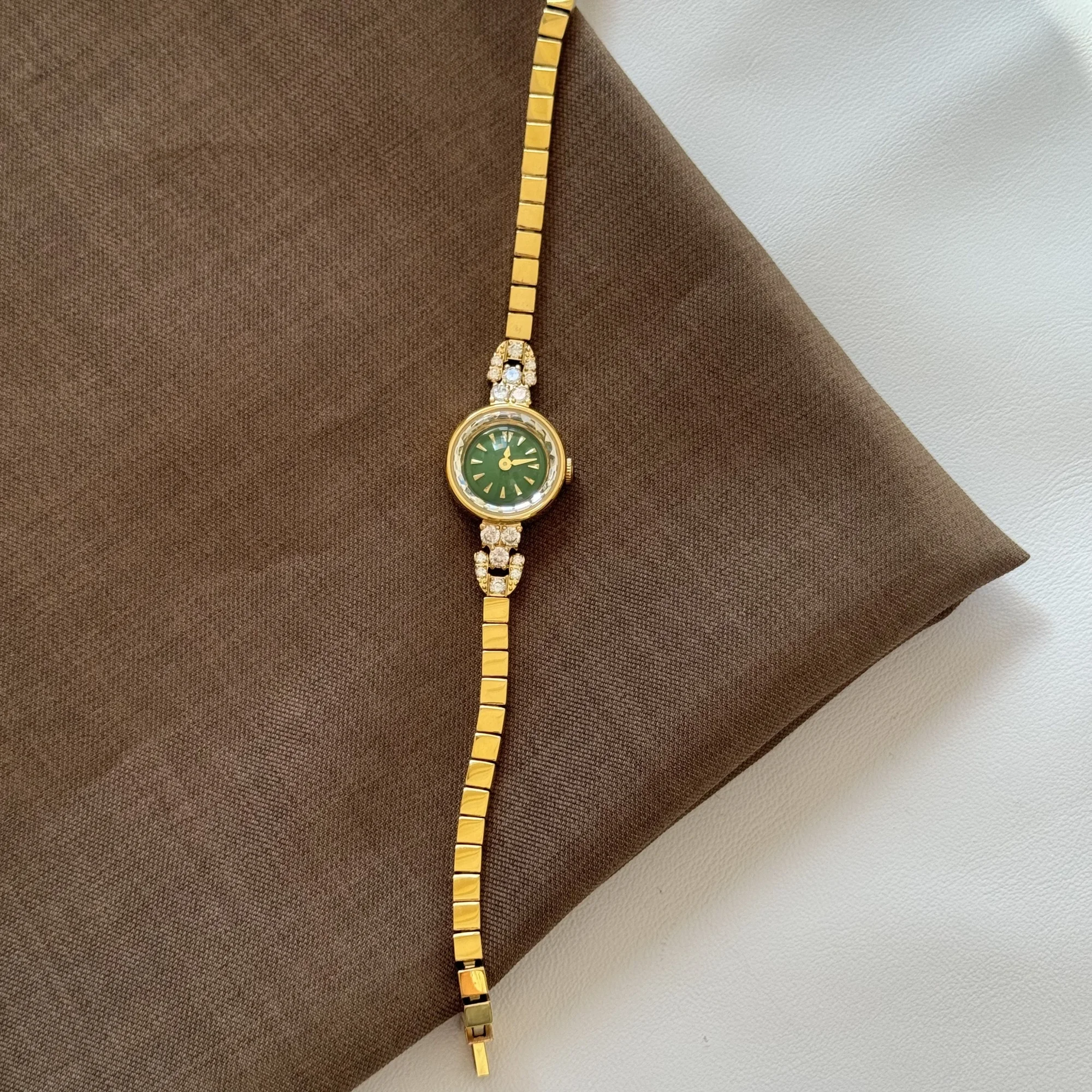 Luxurious gold women's wristwatch featuring a green dial, diamond accents, perfect for elegant occasions.