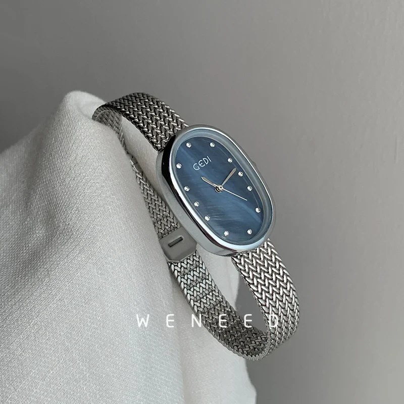 Silver mesh bracelet and blue watch face with minimalist design, perfect for stylish everyday wear.