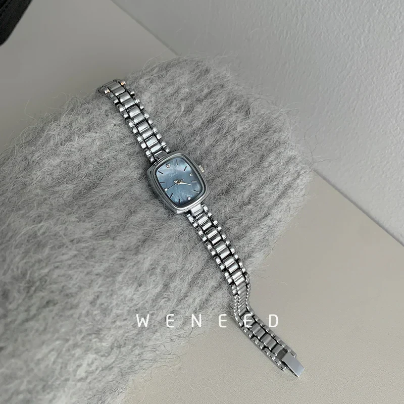 Luxury women’s silver wristwatch with blue face, sleek design, perfect for accessories.