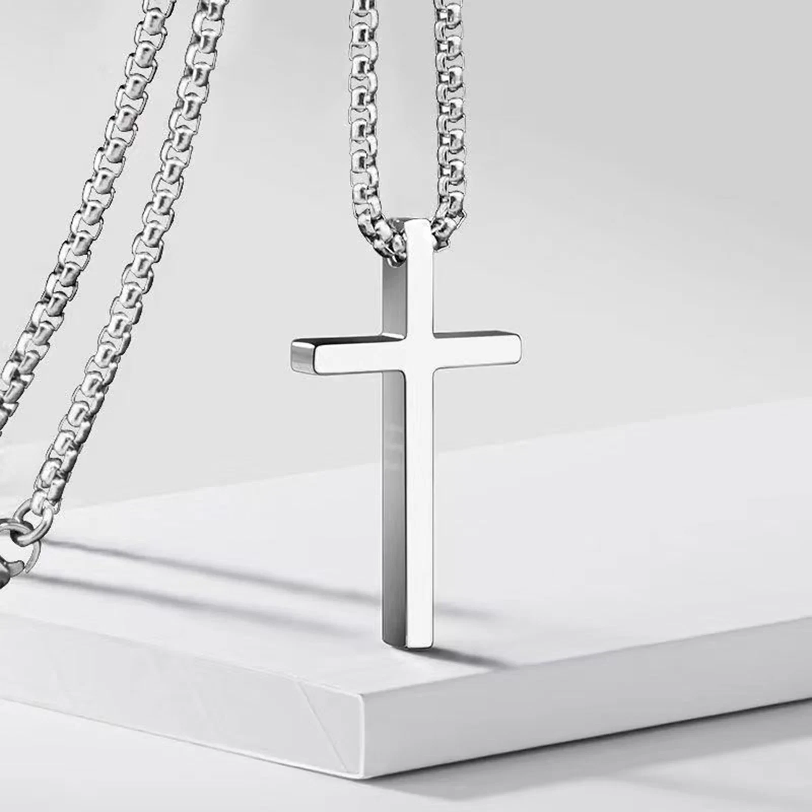 Close-up of a sleek silver cross pendant on a silver chain necklace. Perfect for everyday fashion and spiritual style.