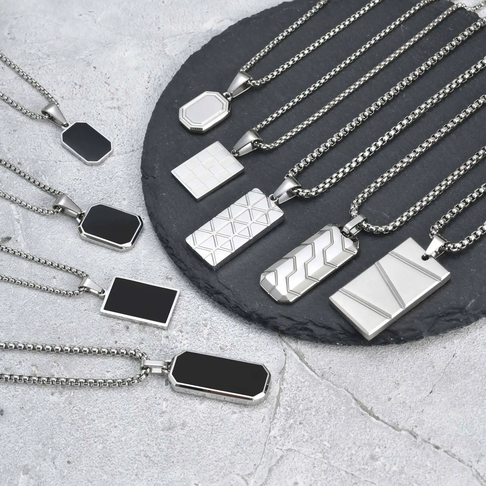 Stacked geometric silver pendant necklaces on chains, stylish jewelry for men and women.