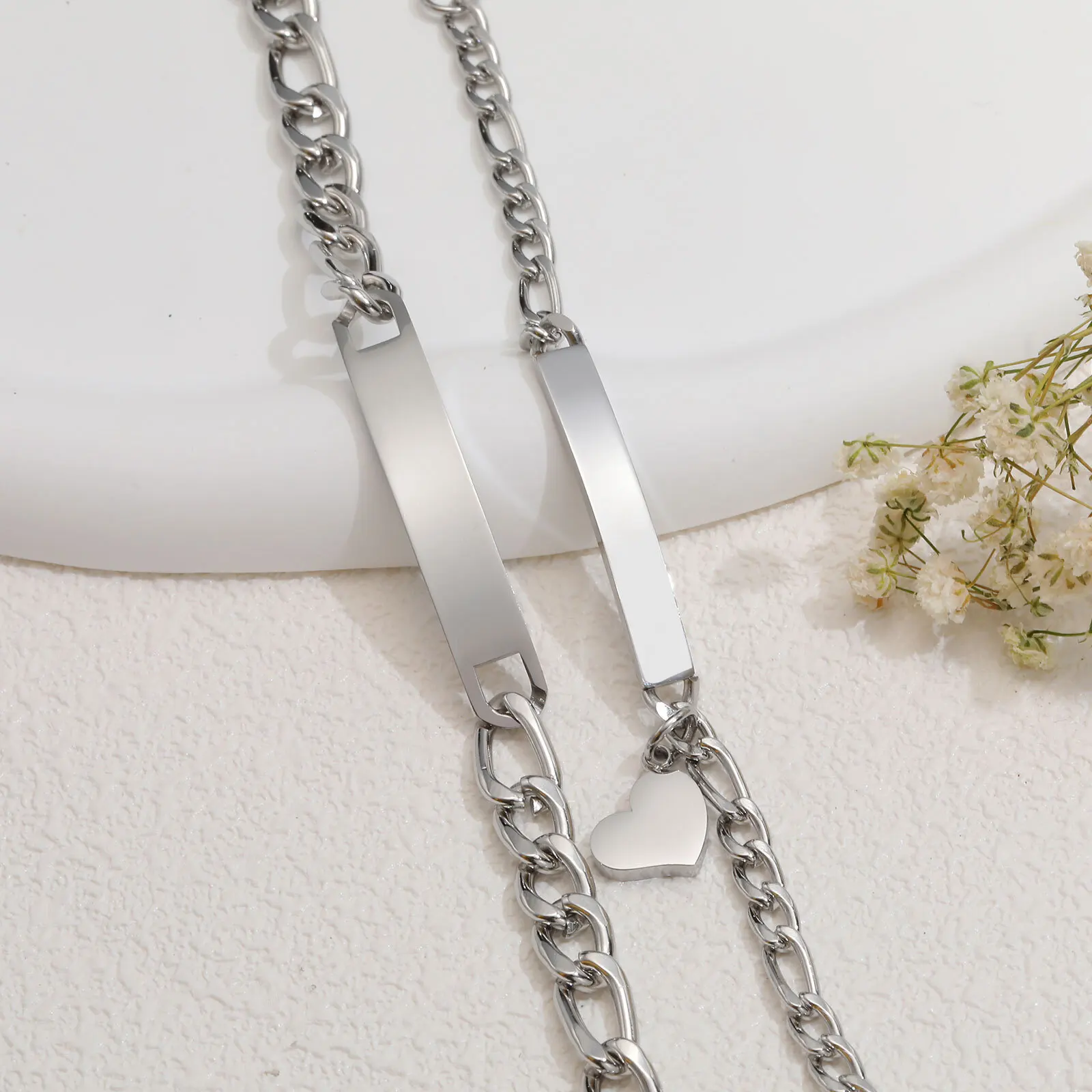 Stainless steel chain with a sleek rectangular pendant and heart charm, perfect for modern jewelry styles.