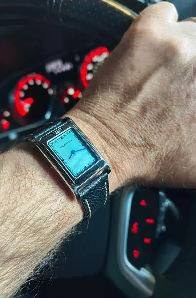 Stylish digital watch on man's wrist with leather strap and modern design.