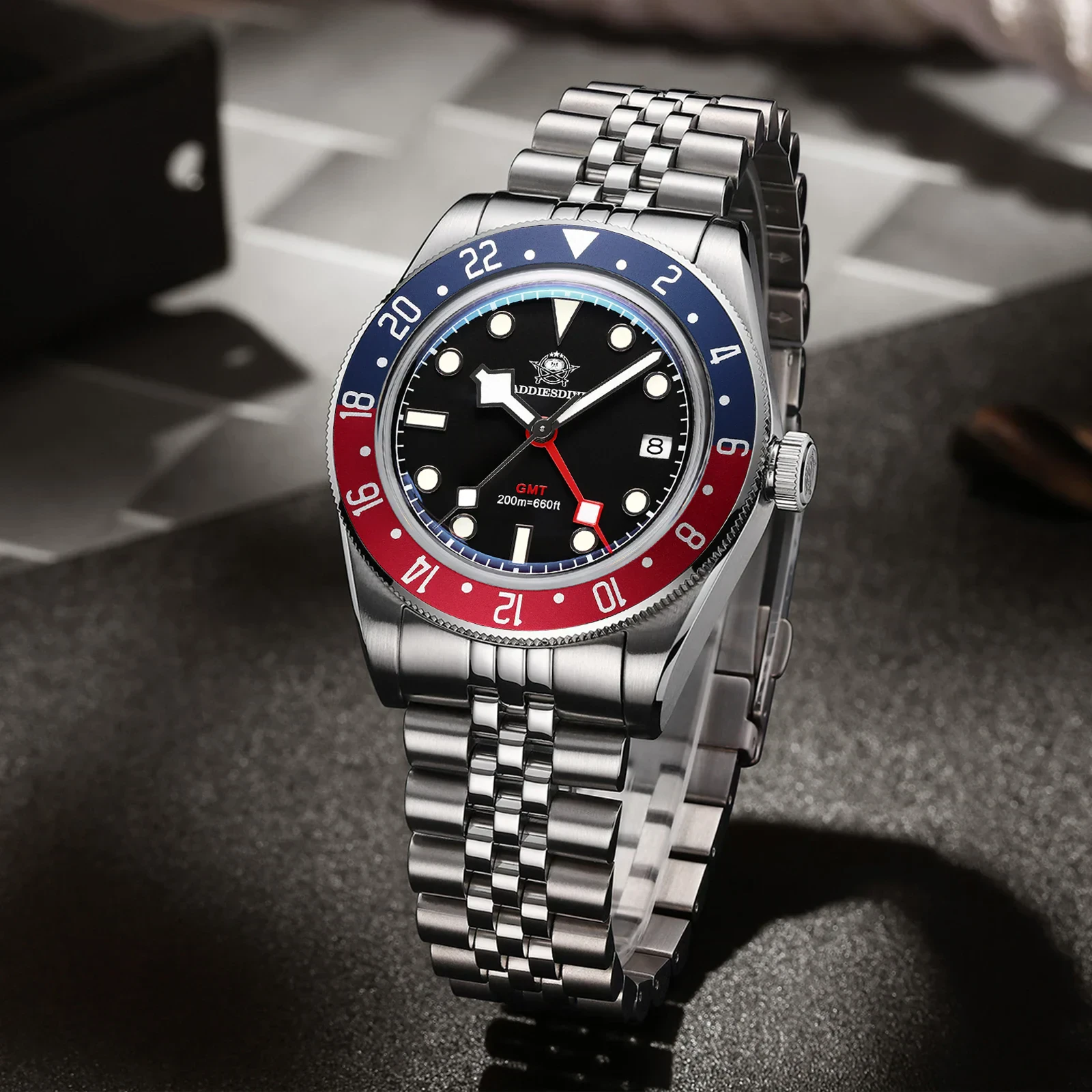 Stainless steel men's GMT watch with bold bezel, black dial, and date window for stylish timekeeping.