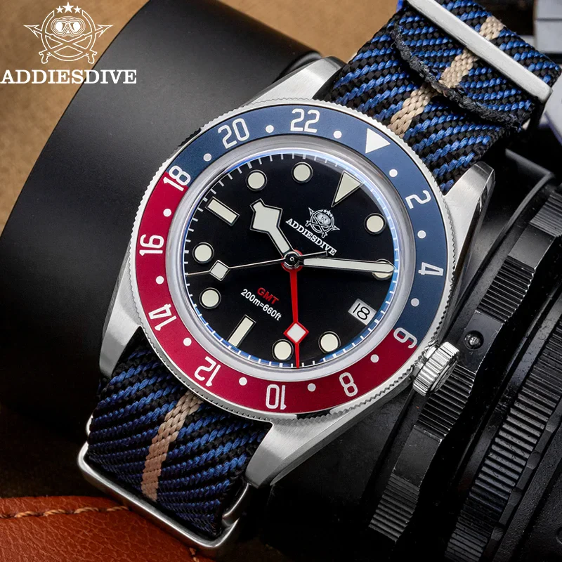 Durable blue and red bezel dive watch with black dial and fabric strap.