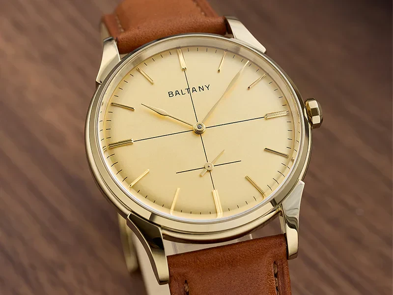 Golden dial with minimalist design, brown leather strap, and classic style.