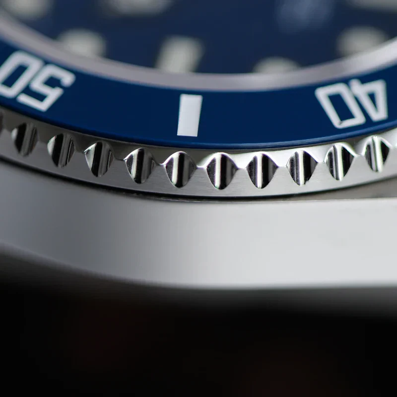 Close-up of a luxury watch bezel with blue dial and silver accents.