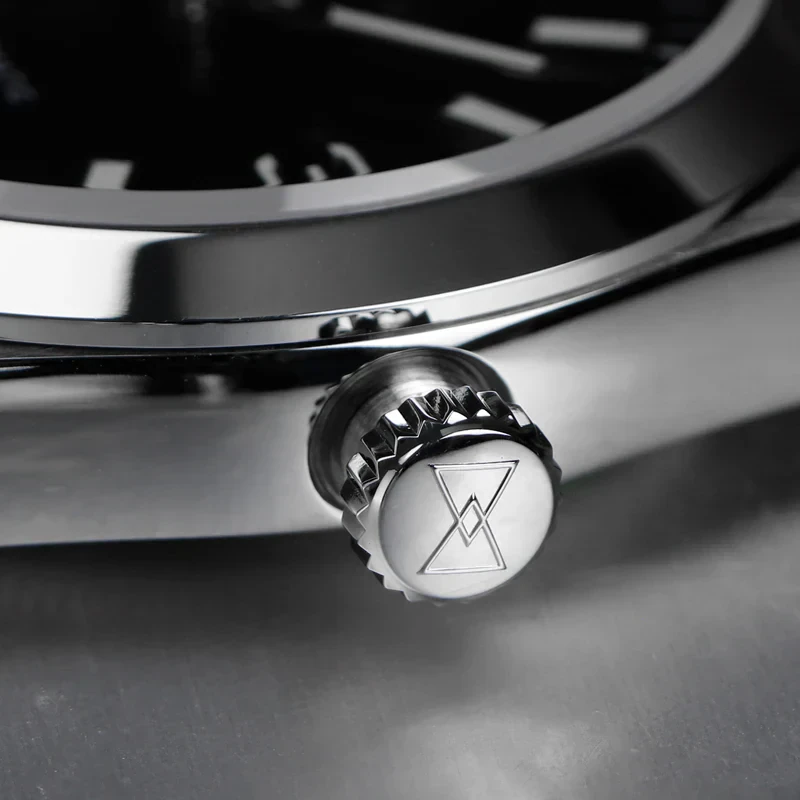Close-up of a watch crown with engraved logo.