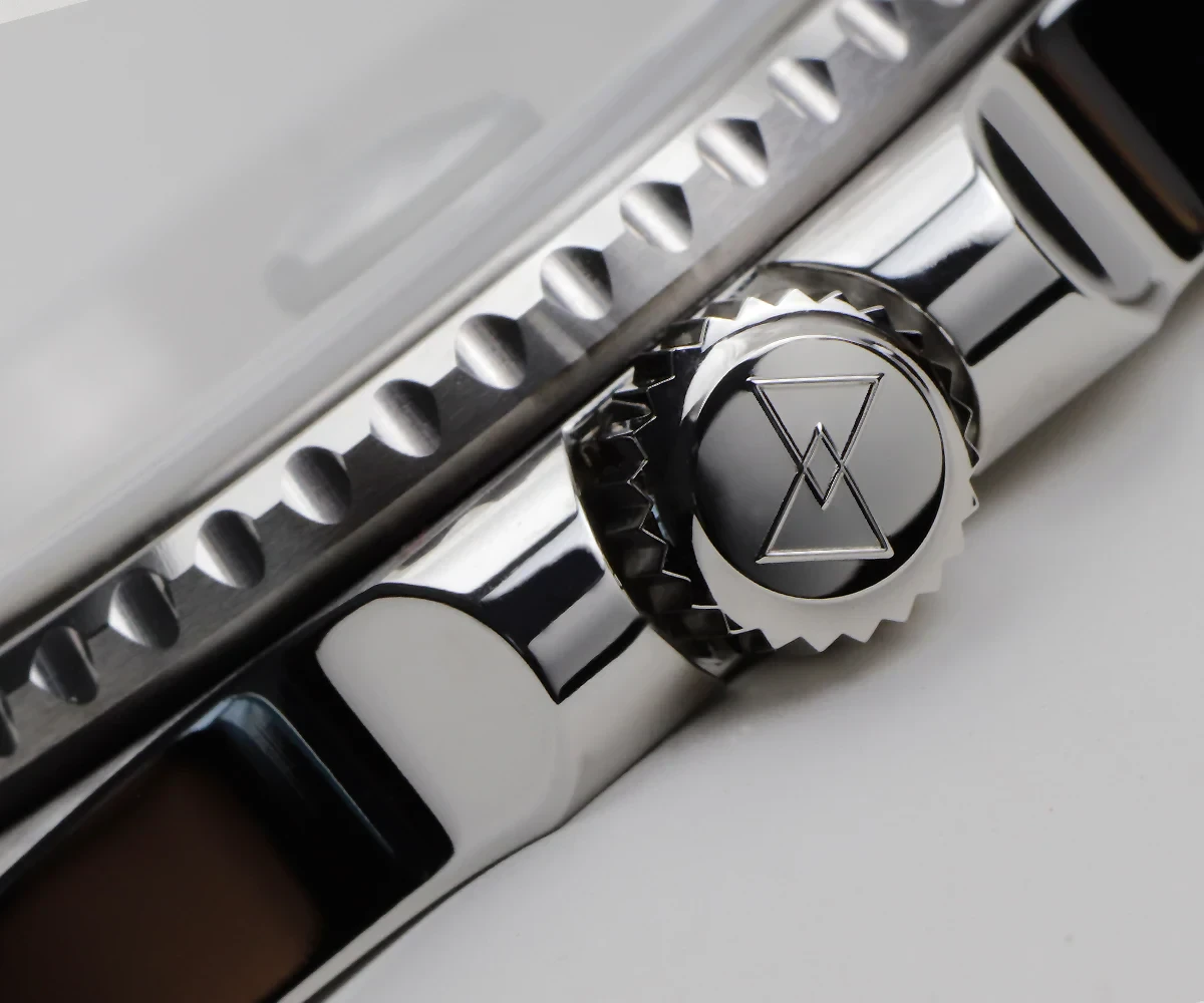 Close-up of a sleek, high-quality chrome safety razor with intricate geometric logo on the knob.