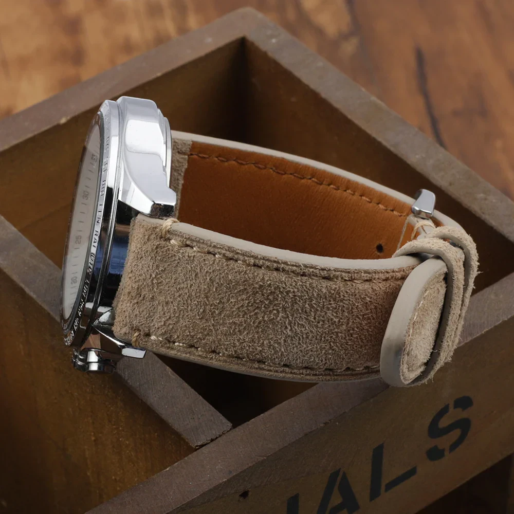 Close-up of a beige distressed leather watch strap with stainless steel buckle on wooden background.