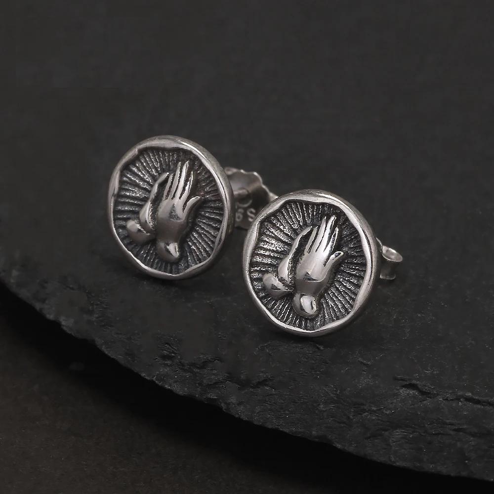 Silver praying hands religious earrings with coin-style design.