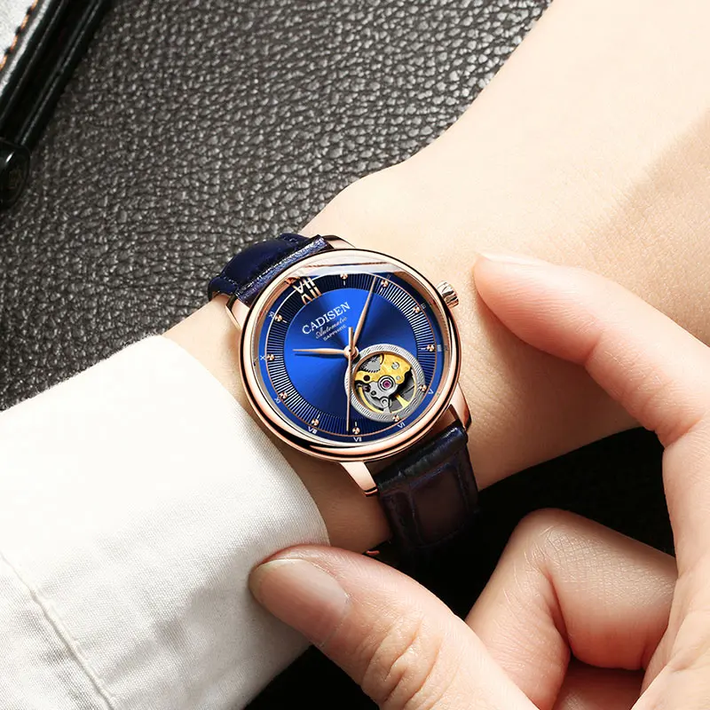 Automatic mechanical wristwatch with blue dial and open-heart design.