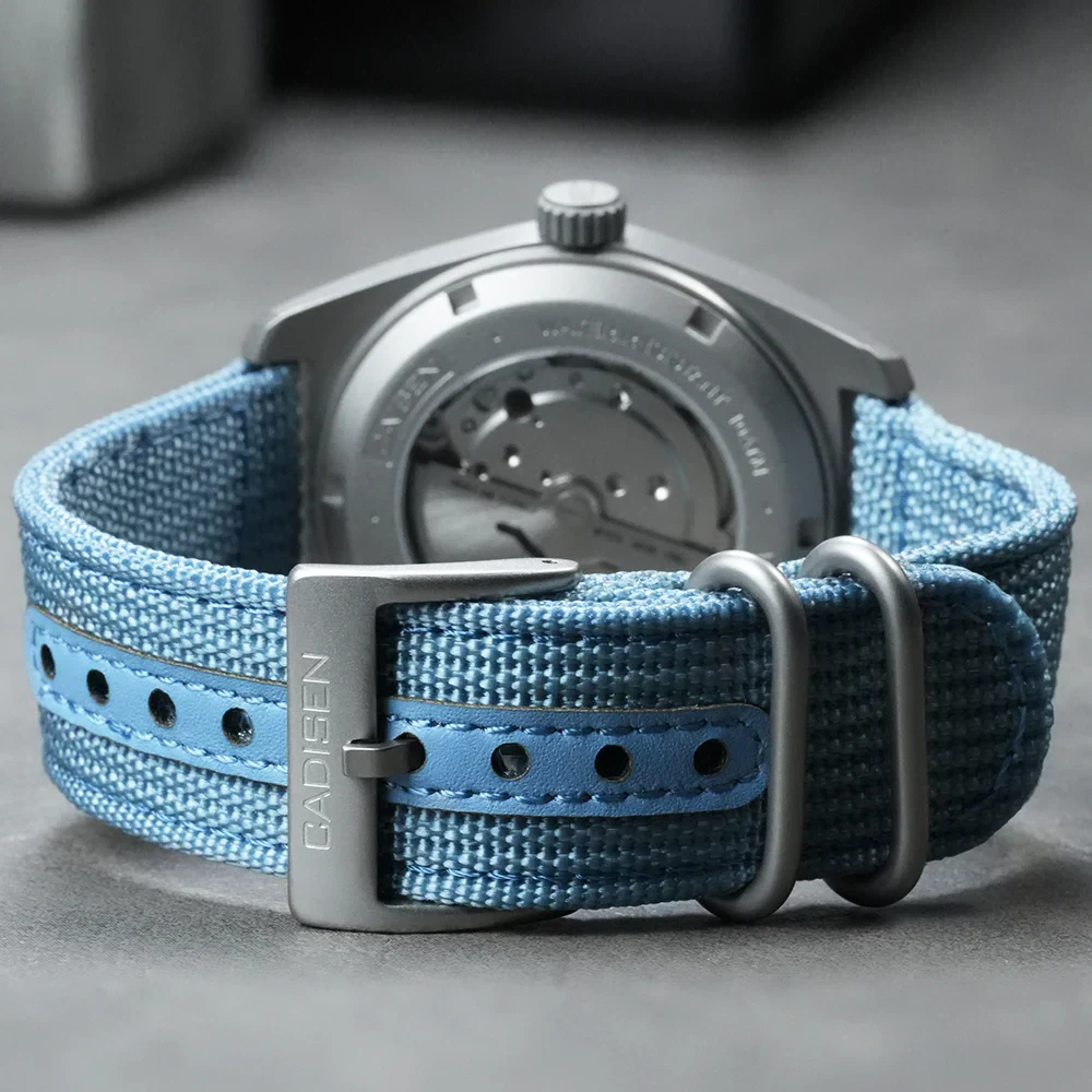 Close-up of CADISEN TI-7 titanium automatic watch with blue canvas strap.