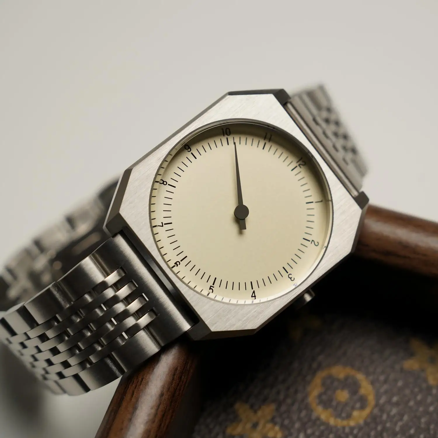 Elegant minimalist men's quartz watch with silver metal band and cream dial.