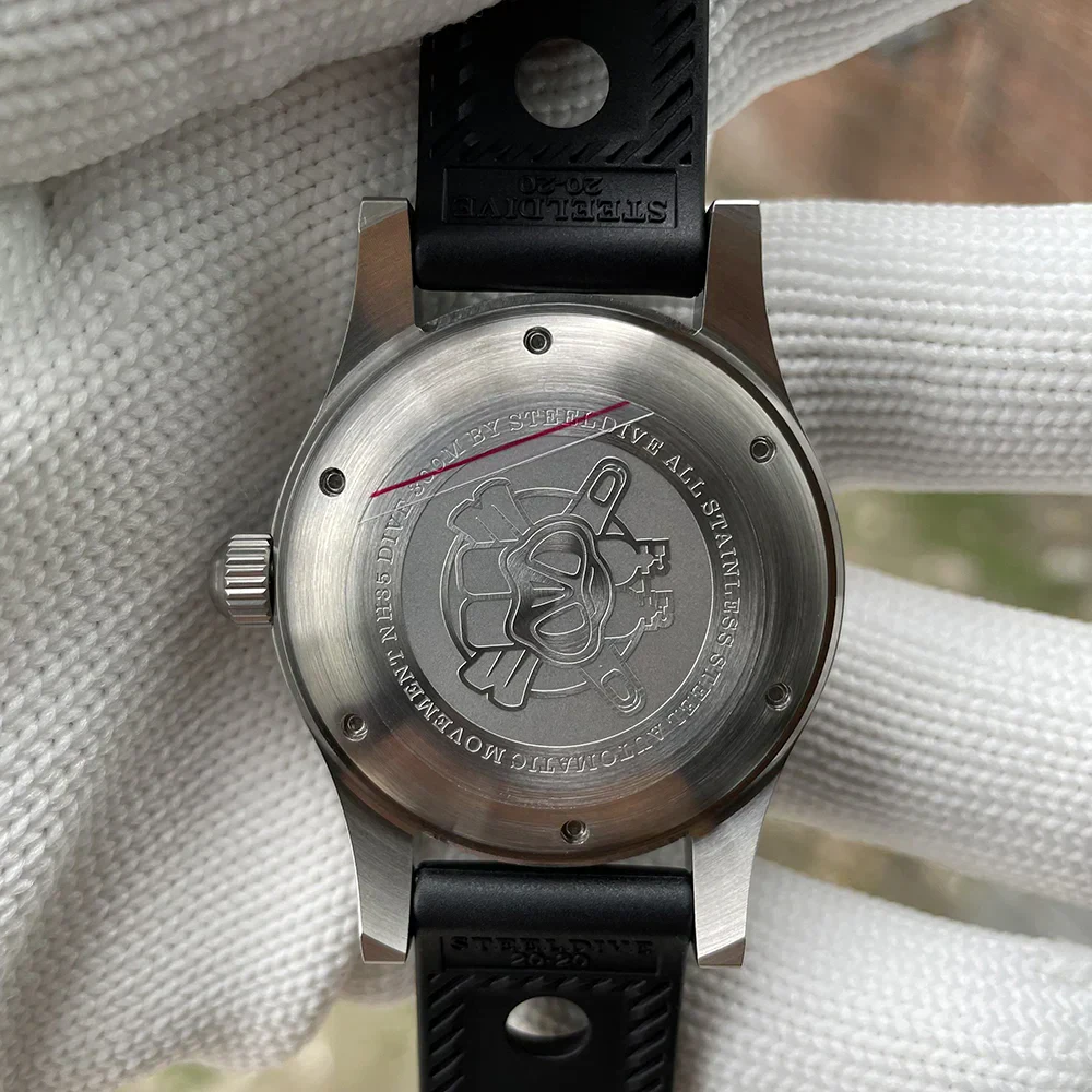Close-up of stainless steel dive watch back with engraved logo and water resistance details.