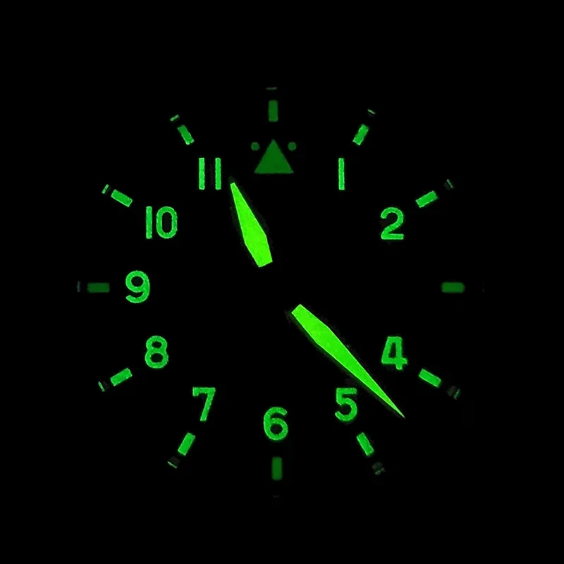 Luminous pilot watch dial with glowing green numerals and hands for easy reading in the dark.