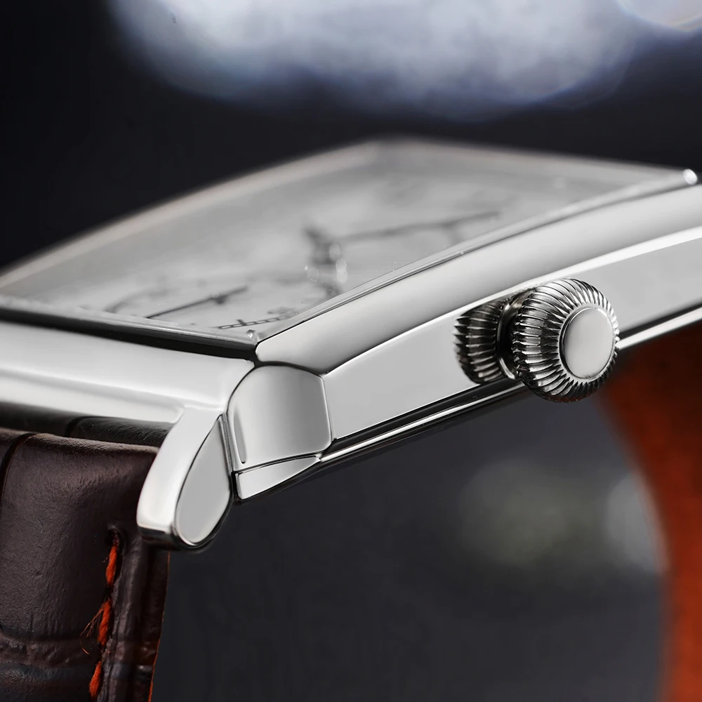 Close-up of a silver watch crown on a luxury wristwatch.