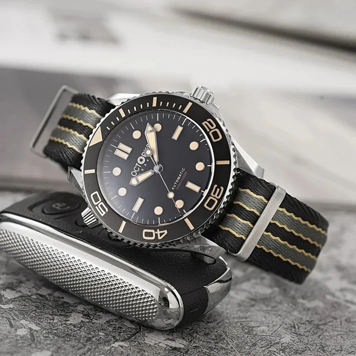 Seiko dive watch with black and gold NATO strap, stainless steel case, and rotating bezel.