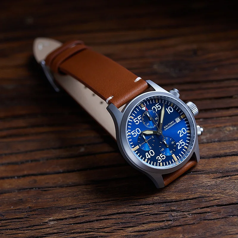 Blue dial chronograph watch with brown leather strap and stainless steel case. Perfect for stylish a.