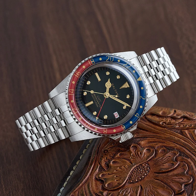 Vintage diver watch with a red and blue bezel, stainless steel bracelet, and black dial.
