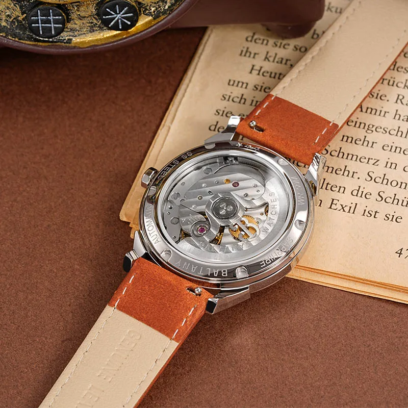 Automatic men's wristwatch with leather band and transparent case back.