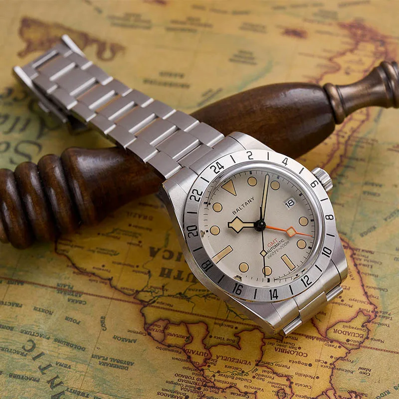 Stainless steel Baltic Aquascaphe GMT watch on vintage map background with chess piece.