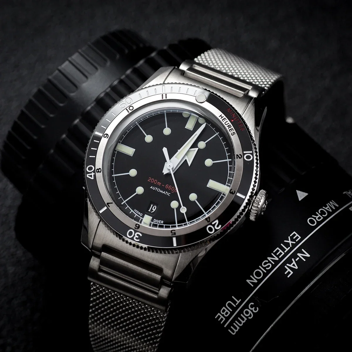 Vintage diver watch with black dial, luminous markers, and stainless steel mesh strap. Perfect for s.