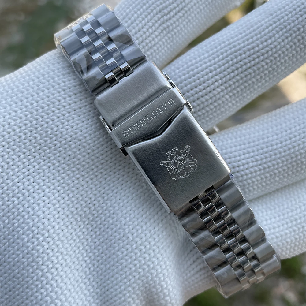 Silver dive watch bracelet with engraved logo on clasp.
