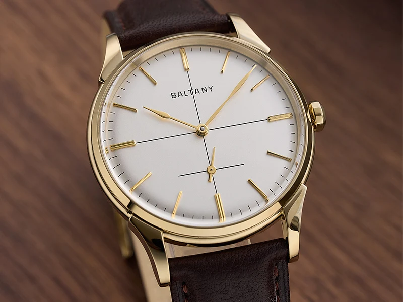 Classic Baltic wristwatch with gold case, white dial, and brown leather strap.