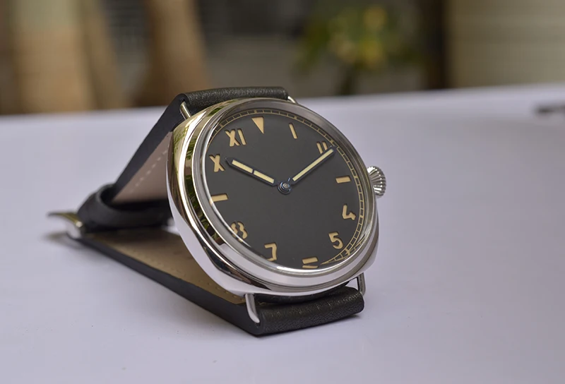 Classic black leather strap wristwatch with gold-tone dial and Roman numerals.